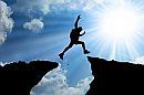 hiker jumping across crevasse